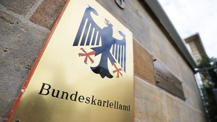 Ein Schild mit Bundesadler hängt vor dem Bundeskartellamt in Bonn. (Symbolbild)