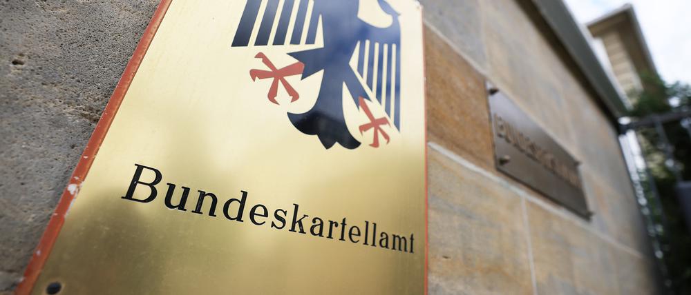 Ein Schild mit Bundesadler hängt vor dem Bundeskartellamt in Bonn. (Symbolbild)