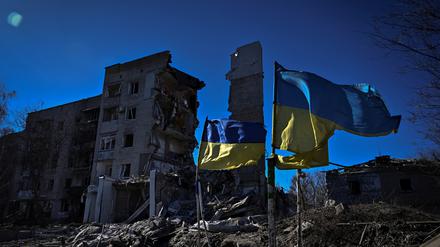 Ukrainische Flaggen über Häuserruinen. 