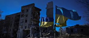 Ukrainische Flaggen über Häuserruinen. 