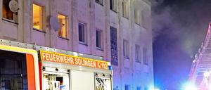 Rauch kommt aus den Fenstern eines Mehrfamilienhauses in Solingen.