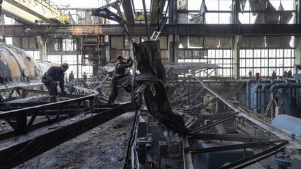 Arbeiter räumen die Trümmer nach einem russischen Raketenangriff auf das DTEK-Kraftwerk in der Ukraine auf.