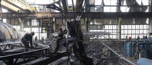 Arbeiter räumen die Trümmer nach einem russischen Raketenangriff auf das DTEK-Kraftwerk in der Ukraine auf.