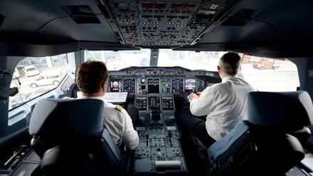 Zwei Piloten arbeiten auf dem Flughafen in Hamburg im Cockpit eines Lufthansa-Airbus A380.