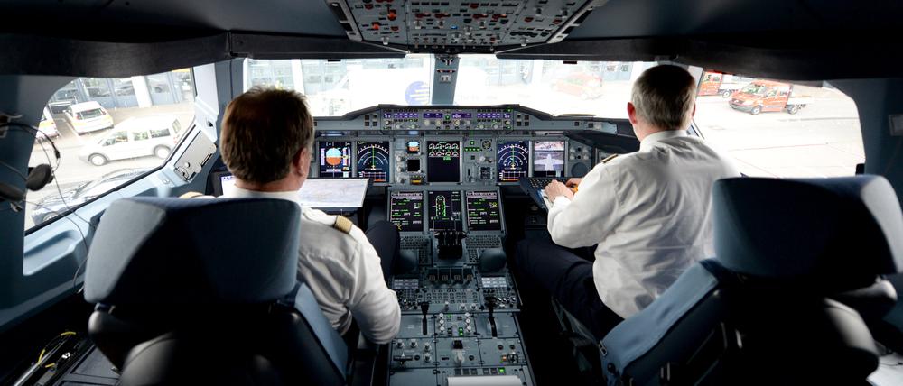 Zwei Piloten arbeiten auf dem Flughafen in Hamburg im Cockpit eines Lufthansa-Airbus A380.