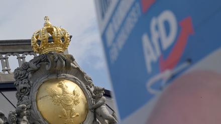 Der märkische Adler, Wappen Brandenburgs, prangt auf dem Dach des Brandenburger Landtags. Im Vordergrund ist ein Wahlplakat der AfD zu sehen. 