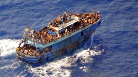 Ein undatiertes Handout-Foto der griechischen Küstenwache zeigt Migranten an Bord eines Bootes während einer Rettungsaktion, bevor ihr Boot auf dem offenen Meer vor Griechenland kentert (Symbolbild).