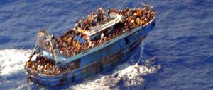 Ein undatiertes Handout-Foto der griechischen Küstenwache zeigt Migranten an Bord eines Bootes während einer Rettungsaktion, bevor ihr Boot auf dem offenen Meer vor Griechenland kentert (Symbolbild).