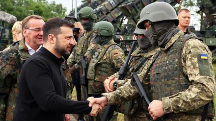Wolodymyr Selenskyj, Präsident der Ukraine, und Bundesverteidigungsminister Boris Pistorius (SPD, l.), begrüßen bei ihrem Besuch auf einem Truppenübungsplatz deutsche und ukrainische Soldaten.