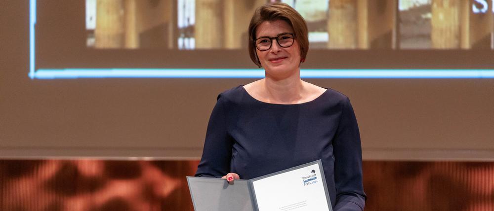 Die Autorin Christina Morina zeigt die Urkunde des Deutschen Sachbuchpreis 2024, den sie für ihr Buch „Tausend Aufbrüche“ erhalten hat. 