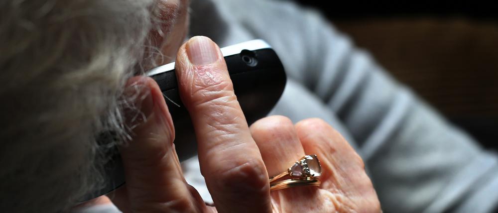 ARCHIV - 11.10.2019, Bayern, Würzburg: Eine ältere Frau telefoniert mit einem schnurlosen Festnetztelefon. (zu dpa: «Mann gibt sich als Polizist aus und betrügt Seniorin um 3000 Euro») Foto: Karl-Josef Hildenbrand/dpa +++ dpa-Bildfunk +++