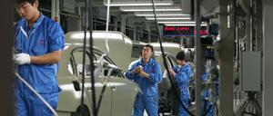 Mitarbeiter im Volkswagen-Werk in Nanjing, nahe Shanghai, China, kontrollieren die Karosserien von Passat-Limousinen für den chinesischen Markt (Symbolbild).