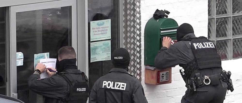 Beamte stehen während der Razzia vor einer Moschee in Braunschweig.