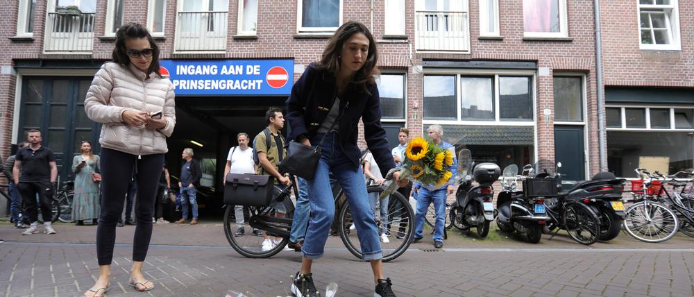 Menschen legen Blumen in Amsterdam für den ermordeten Reporter Peter R. de Vries nieder.