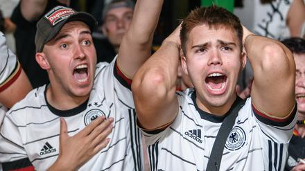 Fußball-Fans in einer Kneipe fiebern beim Public Viewing mit der Nationalelf mit.