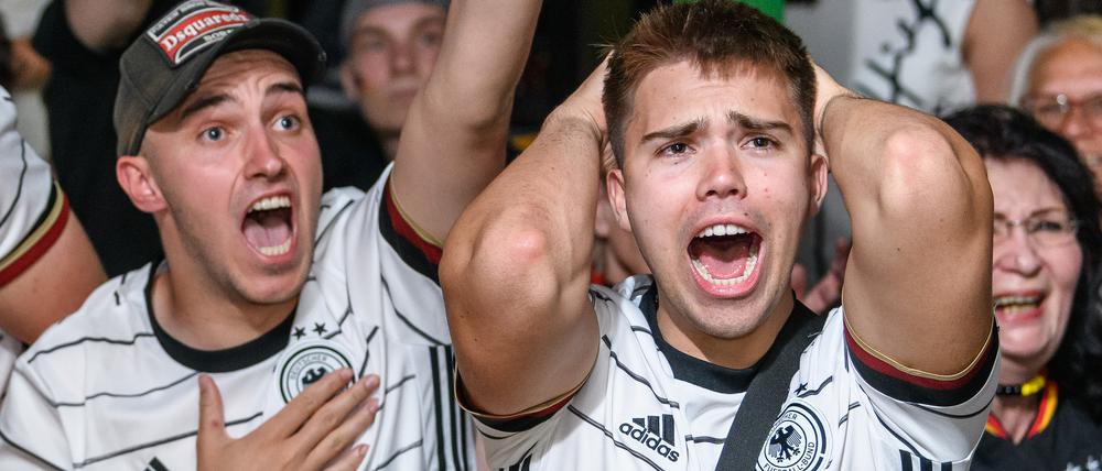 Fußball-Fans in einer Kneipe fiebern beim Public Viewing mit der Nationalelf mit.
