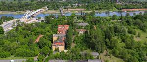 Das Gelände einer ehemaligen Kaserne auf der Oderinsel in Küstrin-Kietz mit dem deutsch-polnischen Grenzfluss Oder dahinter (Luftaufnahme mit einer Drohne).  