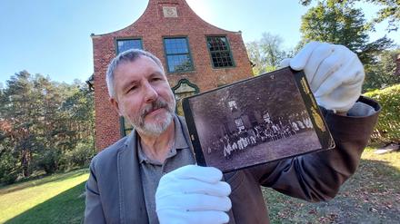Jagdschloß Stern Potsdam. Bernd Küster, Vorsitzender des Fördervereins Jagdschloß, mit der vermutlich ältesten Darstellung einer Jagdgesellschaft vor dem Jagdschoß Stern auf einem Originalfoto von 1894.