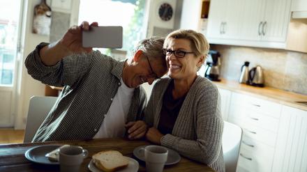 Älteres Paar mit Handy: ein Like für die Liebe.