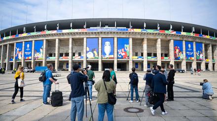 Pressevertreter filmen und fotografieren das Olympiastadion, das für die UEFA EURO 2024 geschmückt ist.