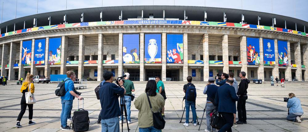 Pressevertreter filmen und fotografieren das Olympiastadion, das für die UEFA EURO 2024 geschmückt ist.