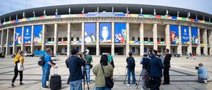 Pressevertreter filmen und fotografieren das Olympiastadion, das für die UEFA EURO 2024 geschmückt ist.