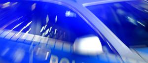 Ein Streifenwagen der Polizei steht mit eingeschaltetem Blaulicht auf der Straße.