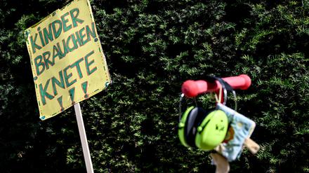 „Kinder brauchen Knete“ steht auf einem Schild bei einer Demonstration.