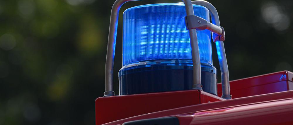 Ein Blaulicht leuchtet auf dem Dach eines Einsatzfahrzeugs der Feuerwehr.