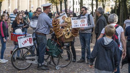 Ein Mann im Tiergarten nähe Brandenburger verkauft Brezeln, die sich in seinem Fahrradkorb stapeln. 