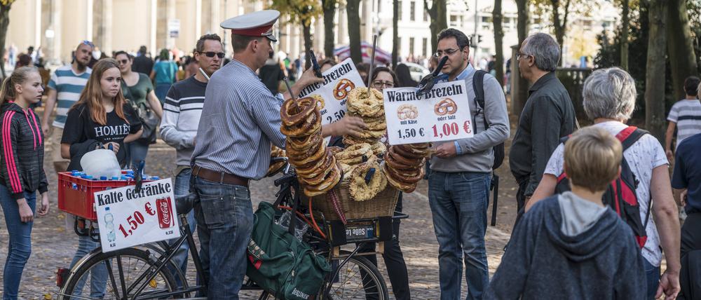 Ein Mann im Tiergarten nähe Brandenburger verkauft Brezeln, die sich in seinem Fahrradkorb stapeln. 