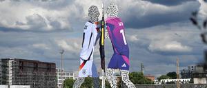 Anlässlich der Fußball-EM tragen die drei Figuren des „Molecule Man“ nun Trikots der deutschen Nationalmannschaft. 