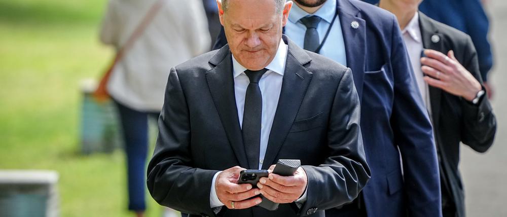 Bundeskanzler Olaf Scholz verlässt mit seinen Sicherheitsbeamten den Tag der deutschen Bauindustrie und geht zu Fuß zum Kanzleramt. 