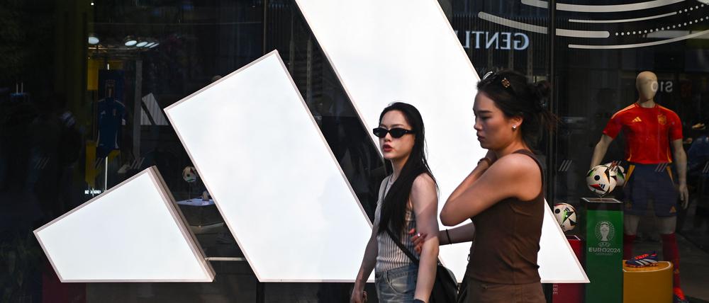 People walk past an Adidas store at a mall in Beijing on June 16, 2024. 
