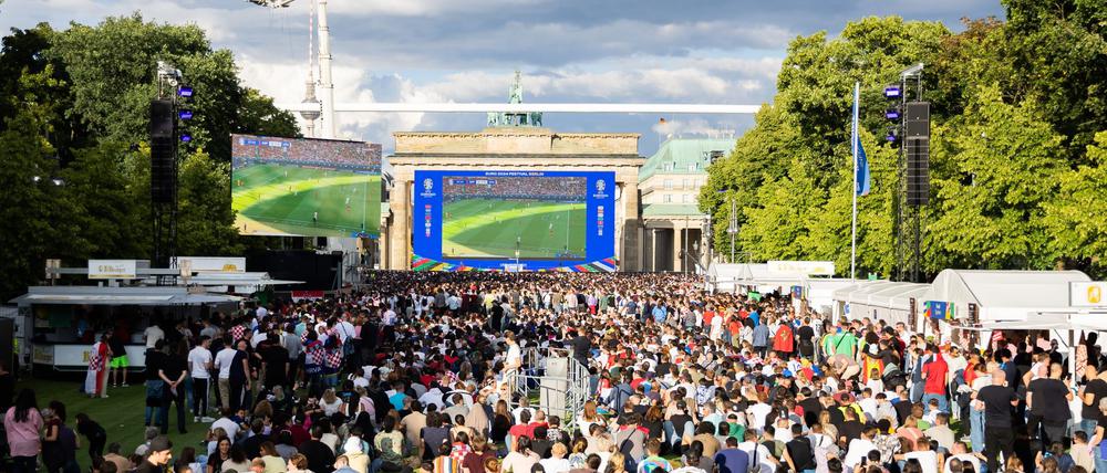 Fans verfolgen beim Public Viewing in der Fanzone vor dem Brandenburger Tor das Spiel.