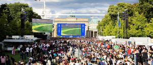 Fans verfolgen beim Public Viewing in der Fanzone vor dem Brandenburger Tor das Spiel.