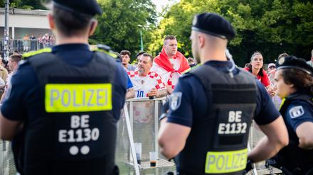 Polizisten stehen beim Public Viewing in der Fanzone am Brandenburger Tor vor kroatischen Fans.