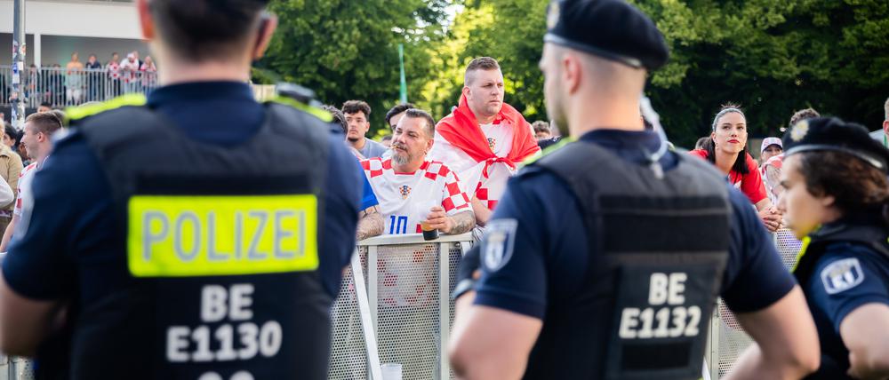 Polizisten stehen beim Public Viewing in der Fanzone am Brandenburger Tor vor kroatischen Fans.