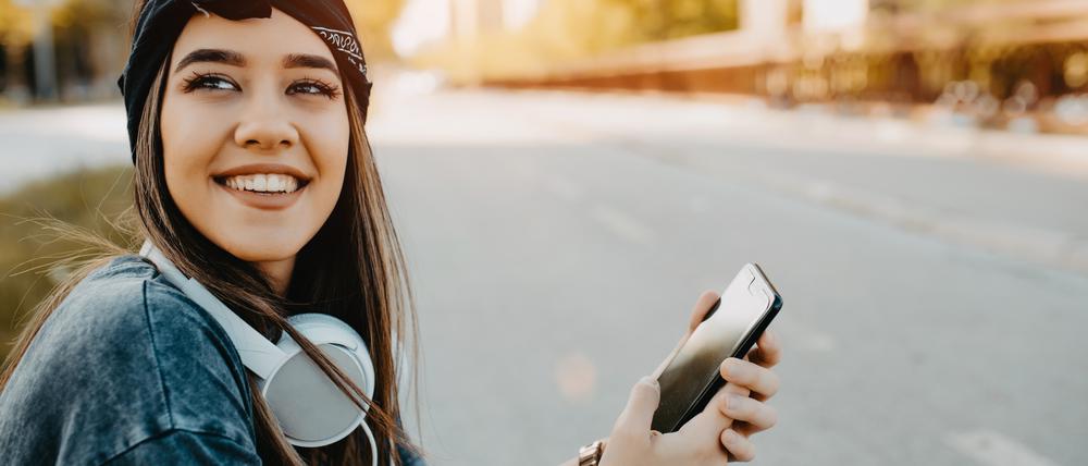 Eine junge Frau hat ihr Smartphone in der Hand. Darüber könnte sie mit Jobflow in wenigen Klicks einen Ausbildungsplatz finden. 