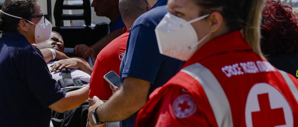 Einige der elf Migranten, die aus dem Meer gerettet wurden, nachdem ihr Segelboot am frühen Morgen im Mittelmeer zwischen Italien und Griechenland gesunken war, werden von der italienischen Küstenwache versorgt. 