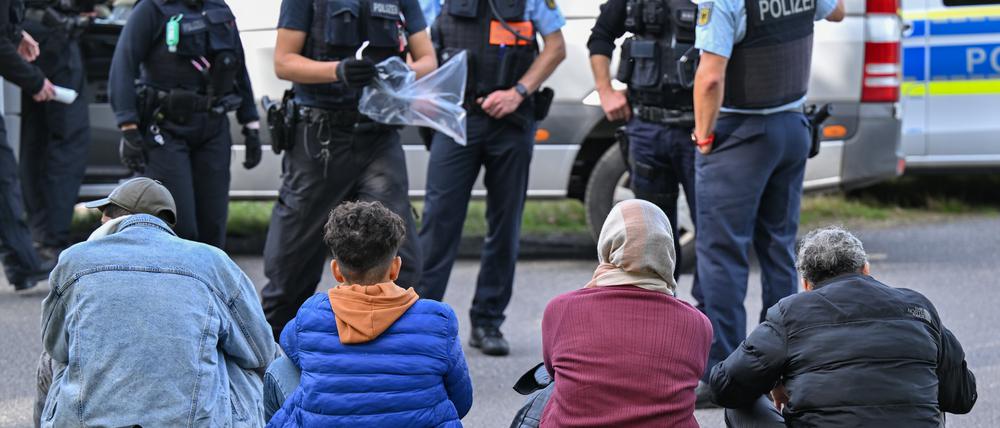 Symboldbild: Unerlaubt eingereiste Migranten werden von Beamten der Bundespolizei bei einem Aufgriff nahe der deutsch-polnischen Grenze in Forst (Lausitz) bewacht. 