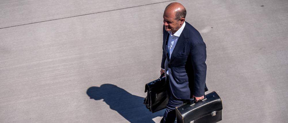 Bundeskanzler Olaf Scholz (SPD) geht über das Rollfeld, um in ein Flugzeug nach Schweden einzusteigen. 