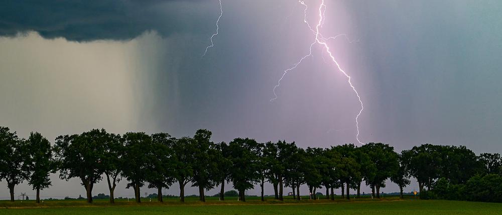 Ein Blitz leuchtet am späten Abend über der Landschaft. 