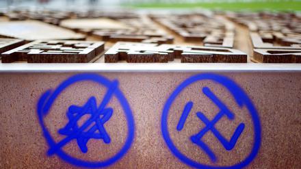 Ein Hakenkreuz und ein durchgestrichener Davidstern sind an einer Gedenkstätte zu sehen. Die Zahl antisemitischer Straftaten ist im ersten Halbjahr in Nordrhein-Westfalen deutlich zurückgegangen. 