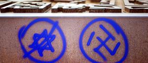 Ein Hakenkreuz und ein durchgestrichener Davidstern sind an einer Gedenkstätte zu sehen. Die Zahl antisemitischer Straftaten ist im ersten Halbjahr in Nordrhein-Westfalen deutlich zurückgegangen. 