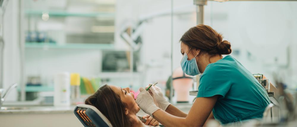 Eine Zahnärztin untersucht das Gebiss einer Patientin.