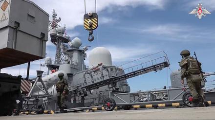Auf diesem vom Pressedienst des russischen Verteidigungsministeriums laden russische Militärangehörige einen Marschflugkörper an Bord eines Kriegsschiffes.