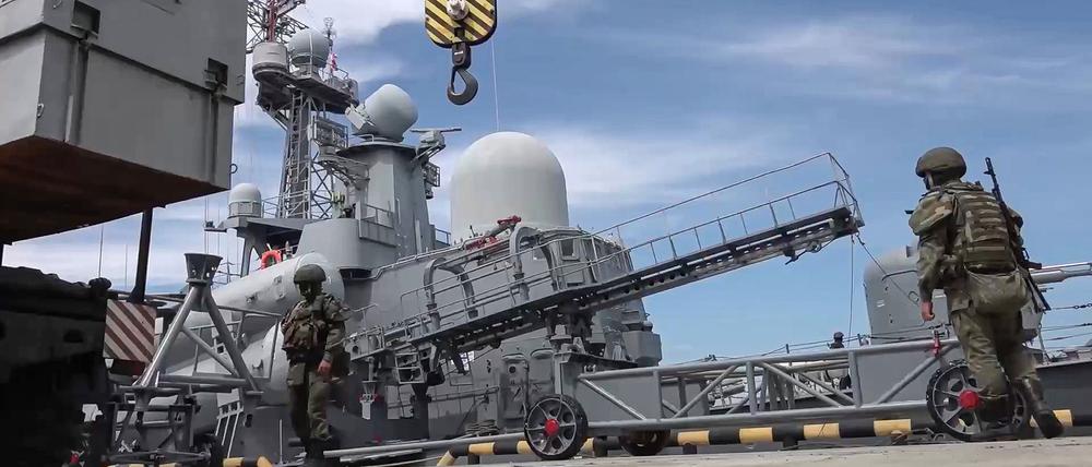 Auf diesem vom Pressedienst des russischen Verteidigungsministeriums laden russische Militärangehörige einen Marschflugkörper an Bord eines Kriegsschiffes.