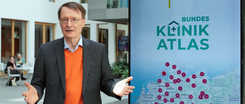 Bundesgesundheitsminister Karl Lauterbach steht neben einem Plakat zum Klinik-Atlas.