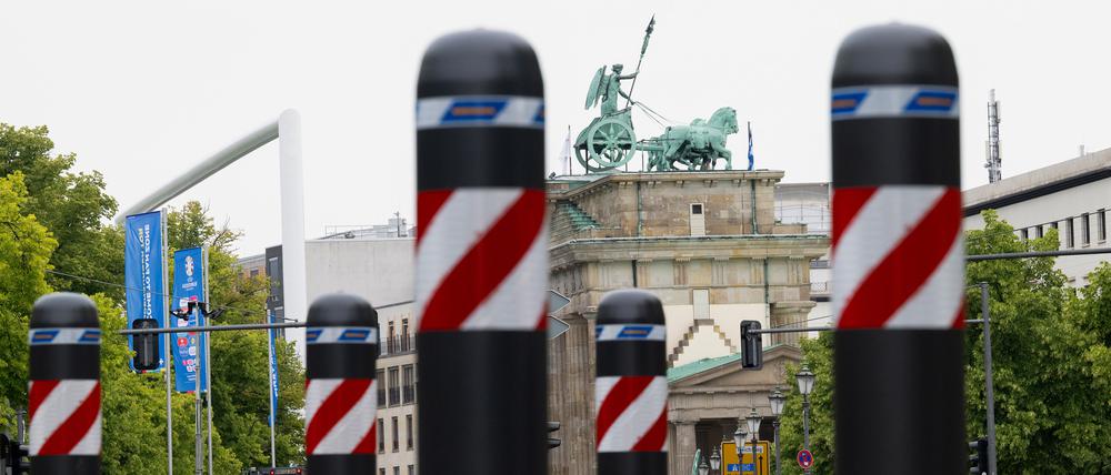 Mobile Poller mit rot-weißer Markierung sind als Absperrung zur Fanzone am Brandenburger Tor bzw. auf der Straße des 17. Juni in der Ebertstraße aufgestellt. 